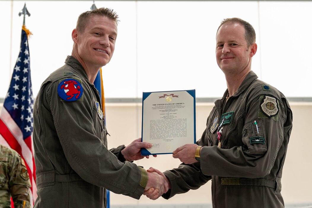 U.S. Air Force Col. Curtis Dougherty (left), 354th Operations Group commander, awards the Meritorious Service Medal to Lt. Col. Ryan Worrell, 356th Fighter Squadron outgoing commander, during a change of command ceremony at Eielson Air Force Base, Alaska, May 17, 2024.