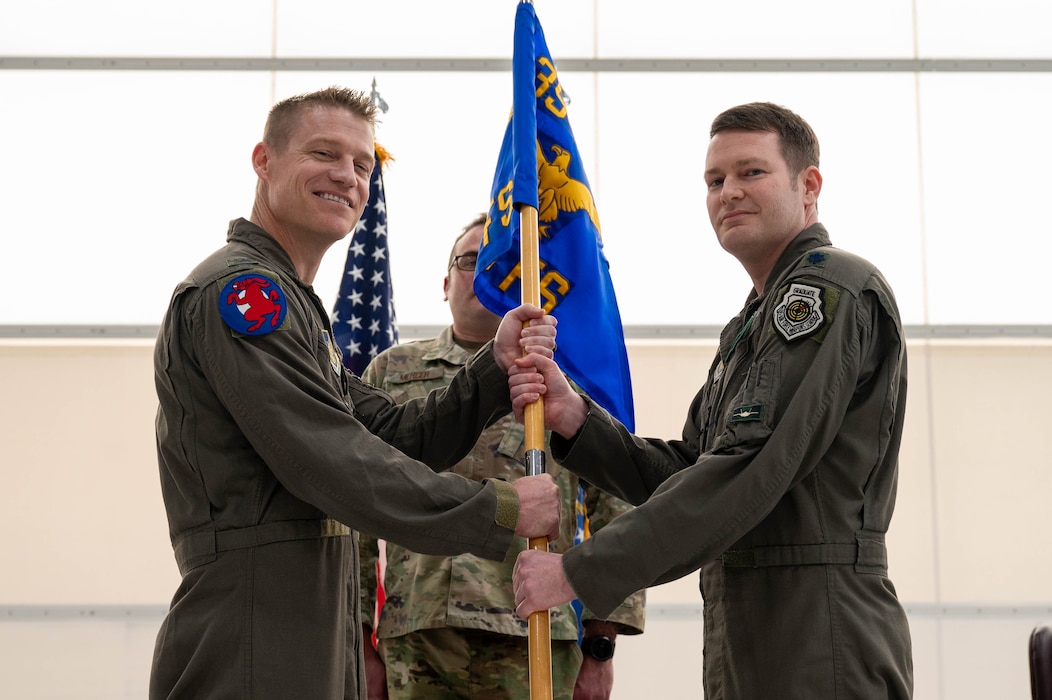 U.S. Air Force Col. Curtis Dougherty (left), 354th Operations Group commander, passes the guidon to Lt. Col. Joseph Curran, 356th Fighter Squadron incoming commander, during a change of command ceremony at Eielson Air Force Base, Alaska, May 17, 2024.