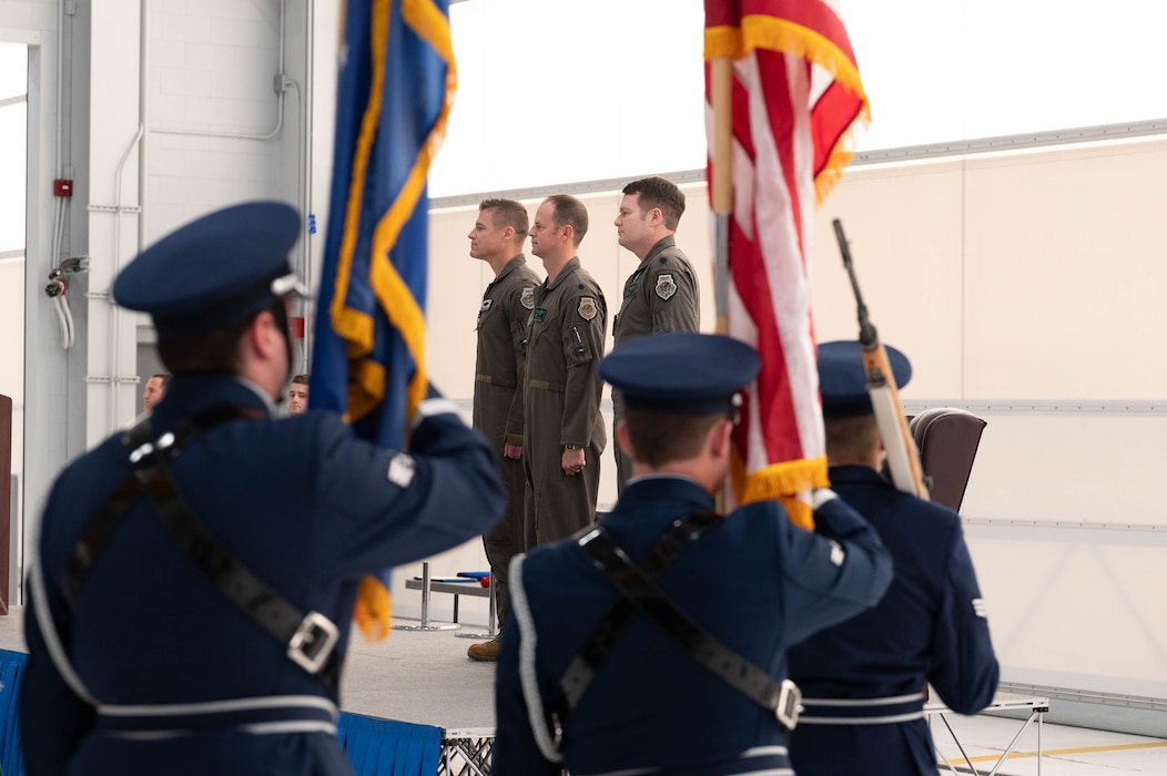 U.S. Air Force Col. Curtis Dougherty (left), 354th Operations Group commander, Lt. Col. Ryan Worrell (middle), 356th Fighter Squadron outgoing commander, and Lt. Col. Joseph Curran, 356th FS incoming commander, stand at attention for the presentation of colors during a change of command ceremony at Eielson Air Force Base, Alaska, May 17, 2024.