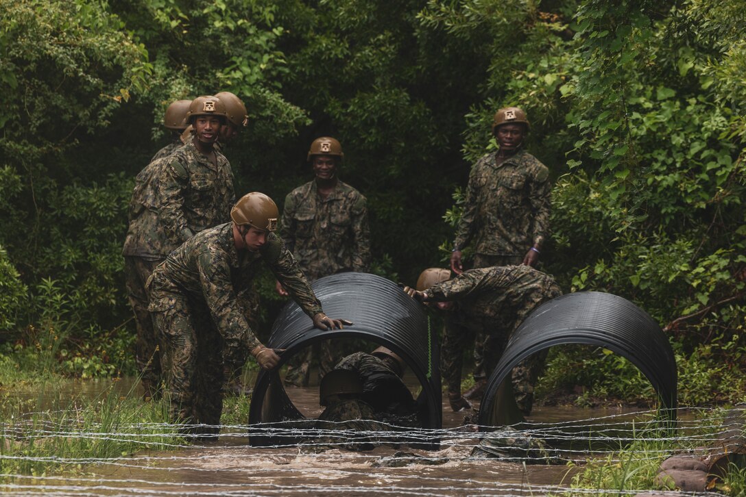 U.S. Naval Academy Midshipmen, with the Naval Academy Football Team, navigate as a team through various obstacles in an Endurance Course, as part of the Career Orientation Training for Midshipmen (CORTRAMID) on Camp Lejeune, North Carolina, May 18, 2024. The CORTRAMID program is a basic introduction and training event to familiarize U.S. Naval Academy Midshipmen with the primary warfare designators that they will serve in, along with providing them with exposure to what is often their first Marine Corps fleet experience. (U.S. Marine Corps photo by Lance Cpl. Jessica J. Mazzamuto)