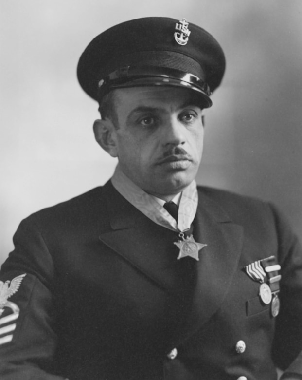 A man wearing a medal around his neck poses for a photo.