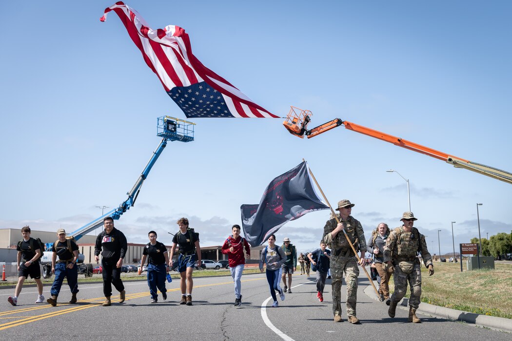 Airman and civilians run carrying a flag