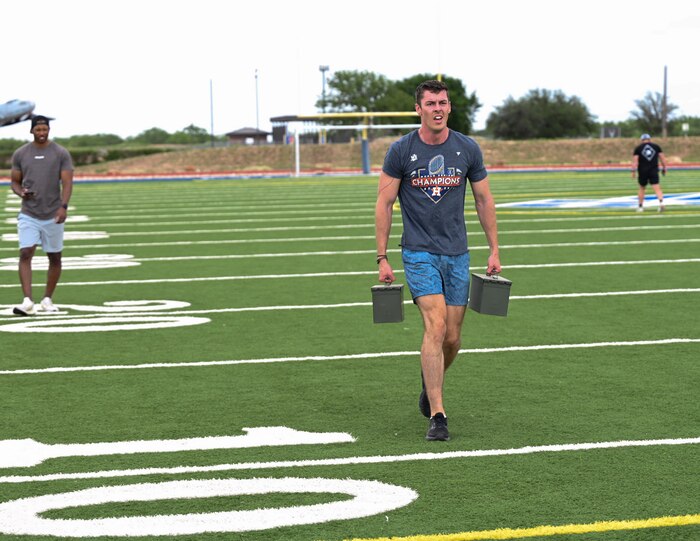 A U.S. Air Force Airman assigned to the 17th Training Wing carries ammunition cans during the National Police Week Defender’s Fitness Challenge at the Mathis Field Track, Goodfellow Air Force Base, Texas, May 15, 2024. The 17th Security Forces Squadron hosted various activities and events throughout the week, including a 5K ruck march, homerun derby and a Defender’s Fitness Challenge. (U.S. Air Force photo by Airman 1st Class Evelyn J. D’Errico)