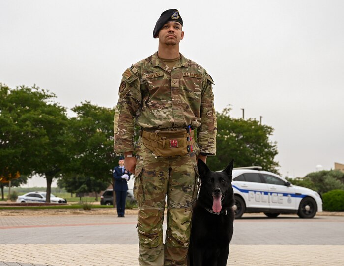 U.S. Air Force Senior Airman Reginald Conyers, 17th Security Forces Squadron military working dog handler, stands at attention with Aragog, 17th SFS MWD, during National Police Week opening ceremony at the Norma Brown building, Goodfellow Air Force Base, Texas, May 13, 2024. The events organized by the 17th SFS throughout the week aimed to not only commemorate the fallen but also foster camaraderie and teamwork among service members. (U.S. Air Force photo by Airman 1st Class Evelyn J. D’Errico)