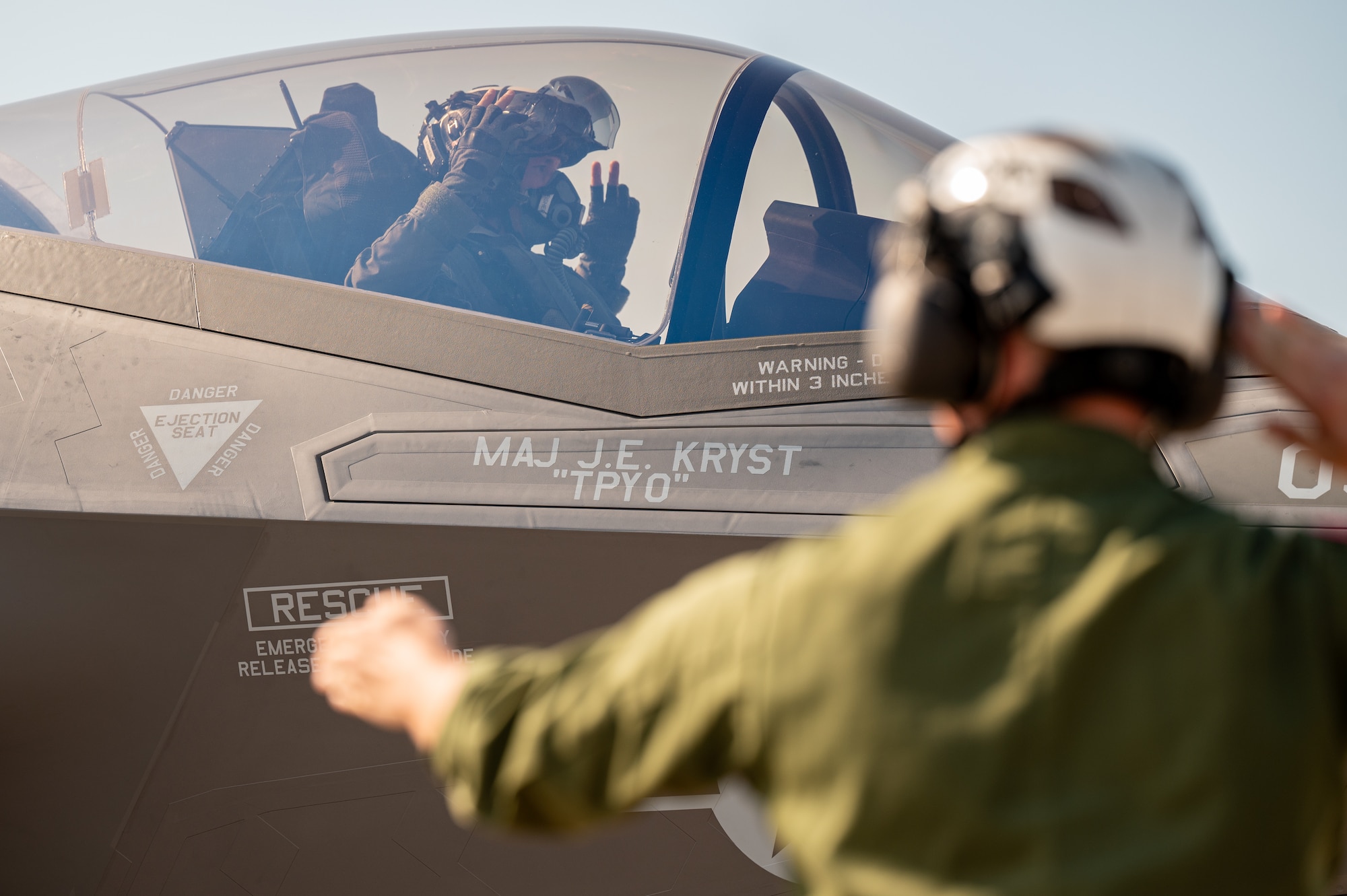 A Marine signals a pilot