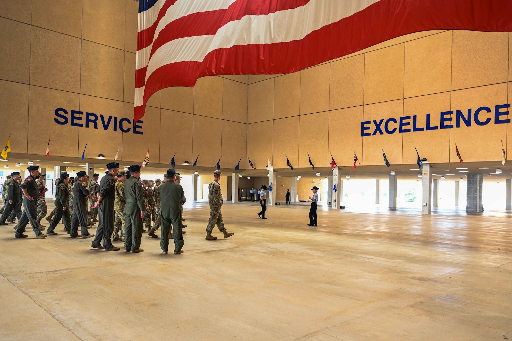Leadership from Altus Air Force Base, Oklahoma, walk under the atrium during a tour of the 331st Training Squadron at the 37th Training Wing, Joint Base San Antonio, Texas, May 15, 2024. Military Training Instructors led the tour to answer questions about how Air Force and Space Force Basic Military Training has evolved over many decades. (U.S. Air Force photo by Senior Airman Kari Degraffenreed)