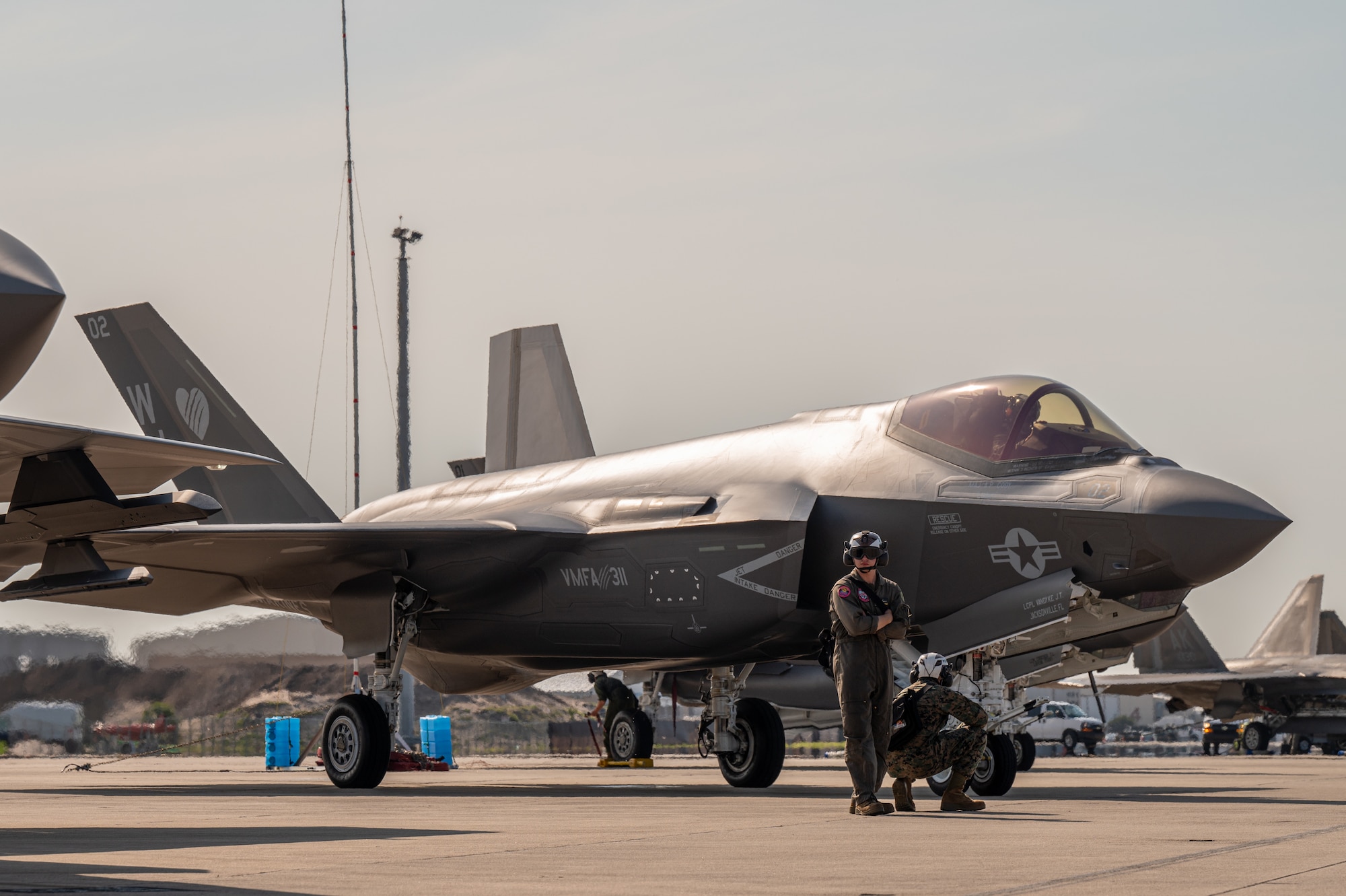 Marines stand on the flight line