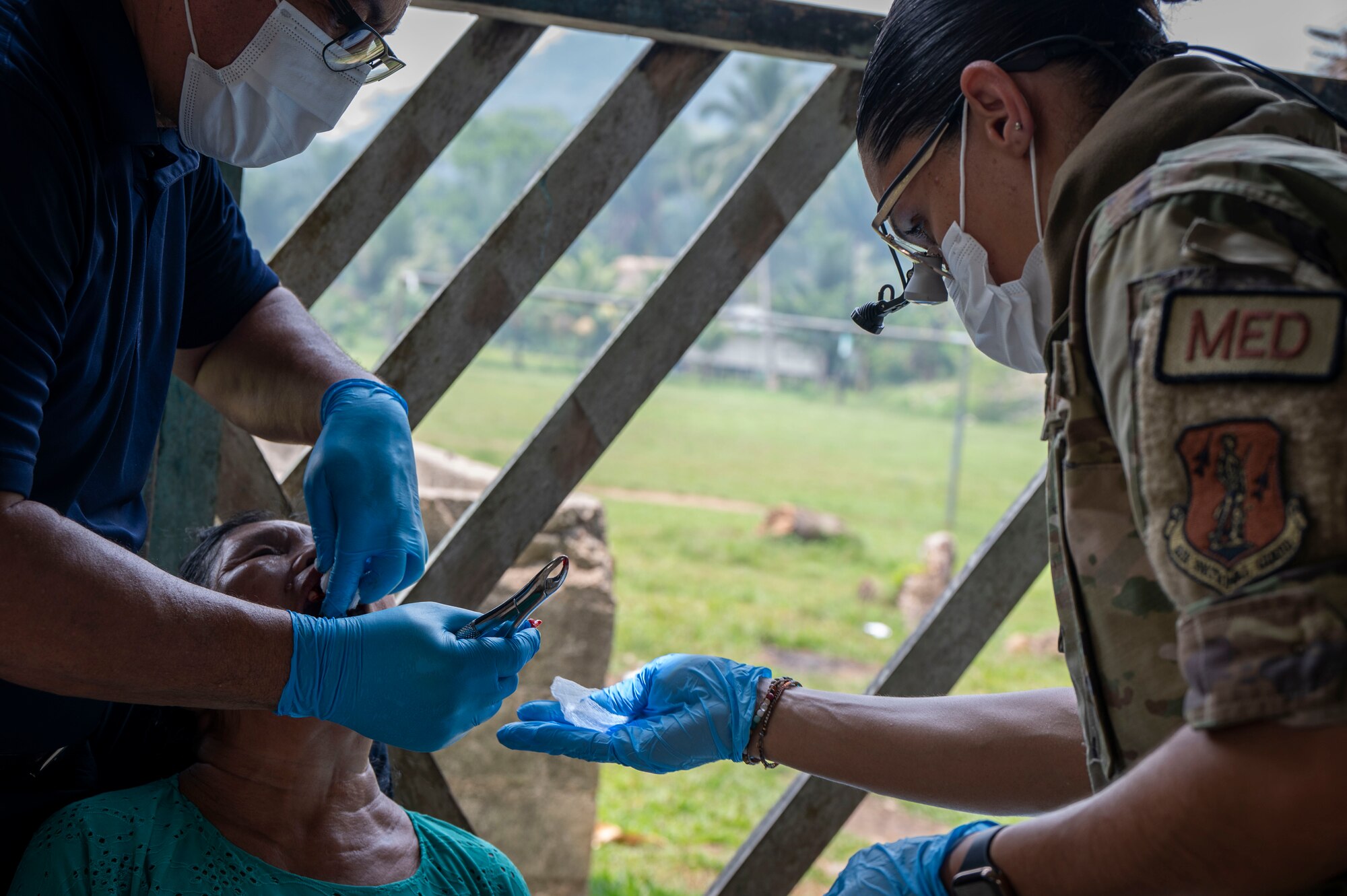 A photo of a person handing a tooth he just extracted to a military member.