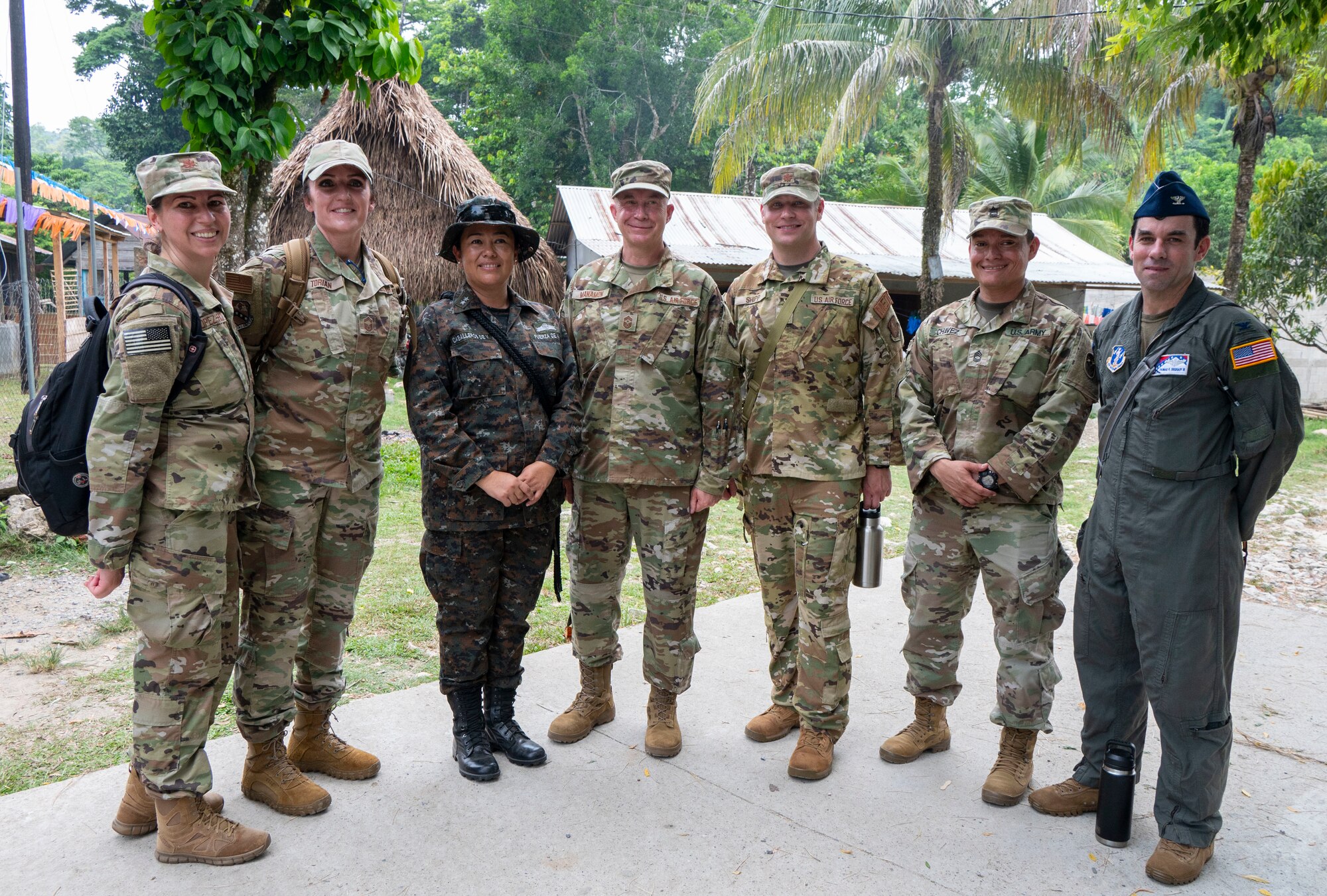 A group of military members from Guatemala and the United States stand in a line, smiling at the camera.