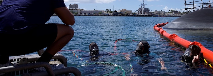 Divers with the Royal Australian Navy and the U.S. Navy check each other’s equipment during a familiarization dive.