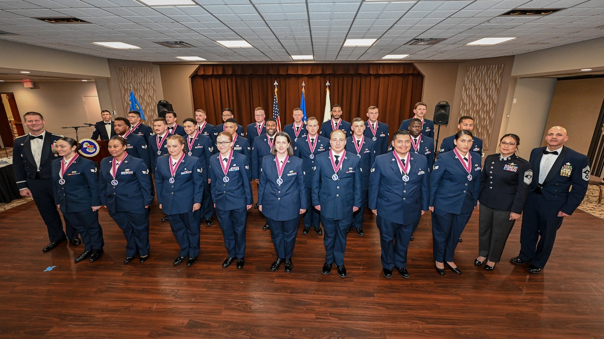 A large group photo of a graduating class of Airmen with two leadership personnel