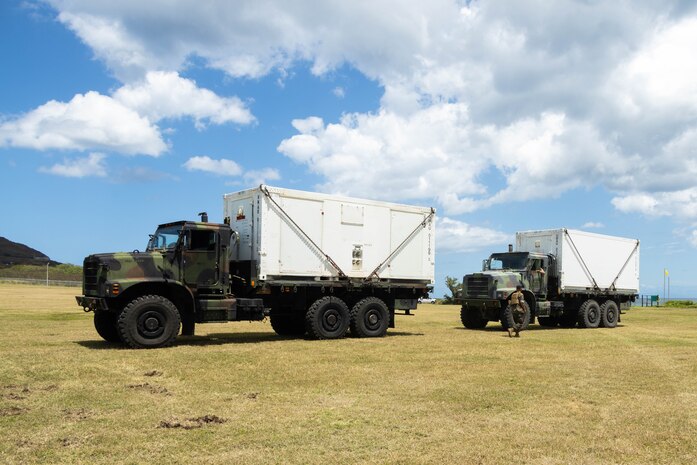 U.S. Marines with Marine Aviation Logistics Squadron (MALS) 24, Marine Aircraft Group 24,1st Marine Aircraft Wing, stage mobile maintenance facilities (MMFs) at Marine Corps Base Hawaii, April 15, 2024. The purpose of MALS-24's Displaced Warrior exercise is to demonstrate their ability to set up MMFs, assist flight operations and deliver supply support in an austere environment. (U.S. Marine Corps photo by Lance Cpl. Tania Guerrero)