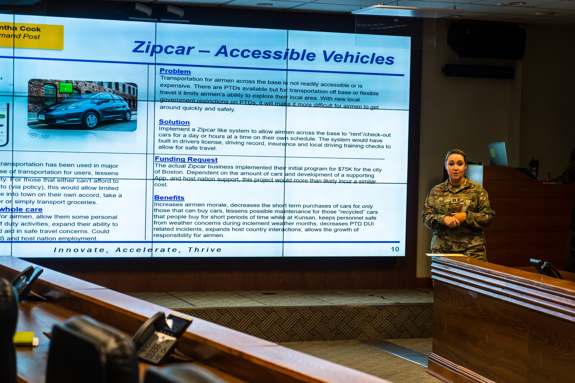 Tech Sgt. Gabrielle Atajar, 8th Healthcare Operations Squadron paramedic, presents her innovative idea to Col. Matthew Gaetke, 8th Fighter Wing commander, during a Wolfwerx event.