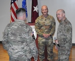 U.S. Army Brig. Gen. (Dr.) Clinton K. Murray (second from left), the commanding general of the U.S. Army Medical Center of Excellence and chief of the U.S. Army Medical Corps (AMC), and U.S. Army Col. (Dr.) Jason Blaylock (right), director of medical services at Walter Reed National Military Medical Center, speak with a Soldier during a leadership professional development briefing at WRNMMC, May 15, 2024.
