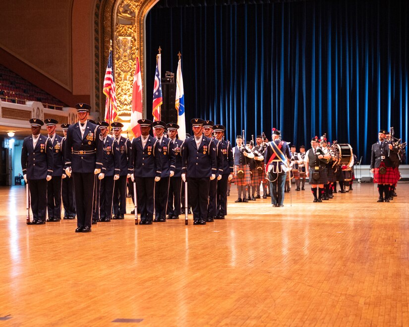 military members stand in formation in an auditorium