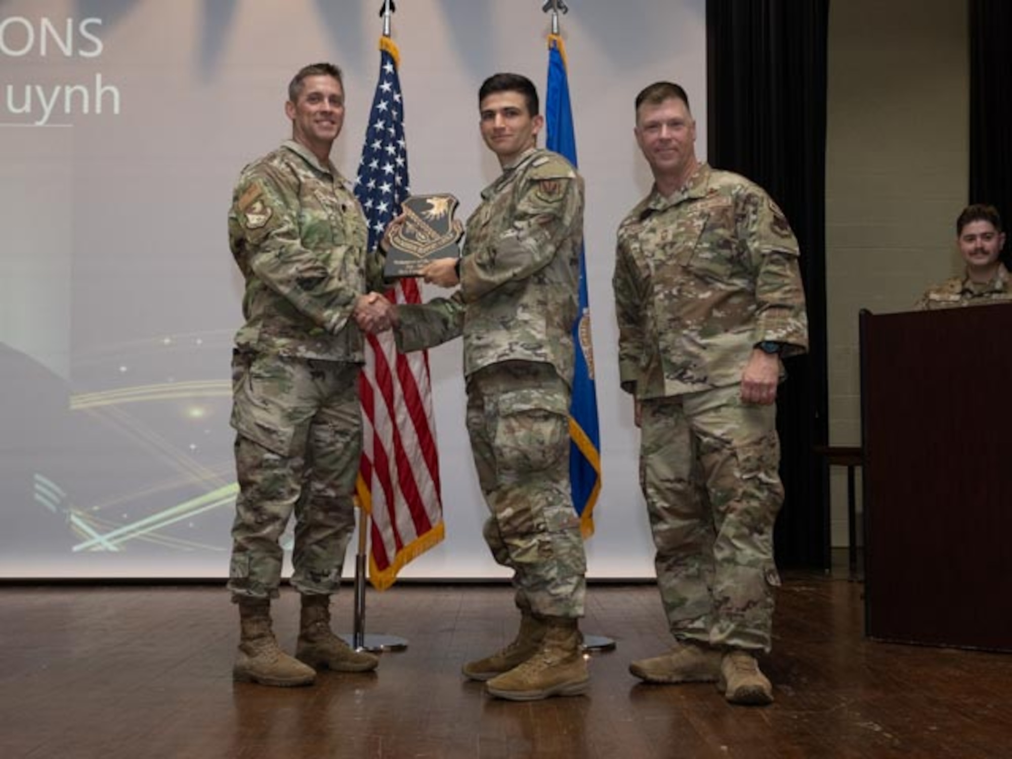 U.S. Air Force Lt. Col. James Melvin, left, Mission Support Group deputy commander, and Chief Master Sgt. Edward Mueller, right, Mission Support Group senior enlisted leader, 1st Lt. Franco Chiappori, center, who accepts the award on behalf of Senior Airman Cuong Huynh, contracting specialist,  Volunteer of the First Quarter Award at Seymour Johnson Air Force Base, North Carolina, April 19, 2024. The ceremony recognized 10 individual award winners and one team for outstanding performance. (U.S. Air Force photo by Airman Megan Cusmano)