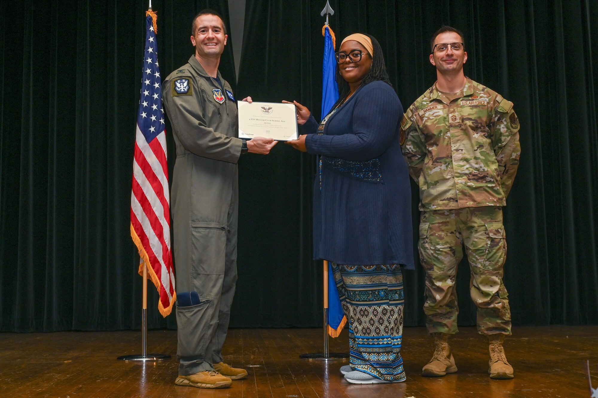 Col. Morgan Lohse, left, 4th Fighter Wing commander, and Chief Master Sgt. Paul Hammer, right, 4th Fighter Wing command chief, present the Bronze Presidential Volunteer Service Award to a Seymour Johnson Air Force Base volunteer during a volunteer appreciation ceremony at Seymour Johnson Air Force Base, North Carolina, April 26, 2024. The Bronze award winners have completed 100 to 174 hours for young adults, 100 to 249 hours for adults and 200 to 499 for families and groups. (U.S. Air Force photo by Airman Rebecca Tierney)