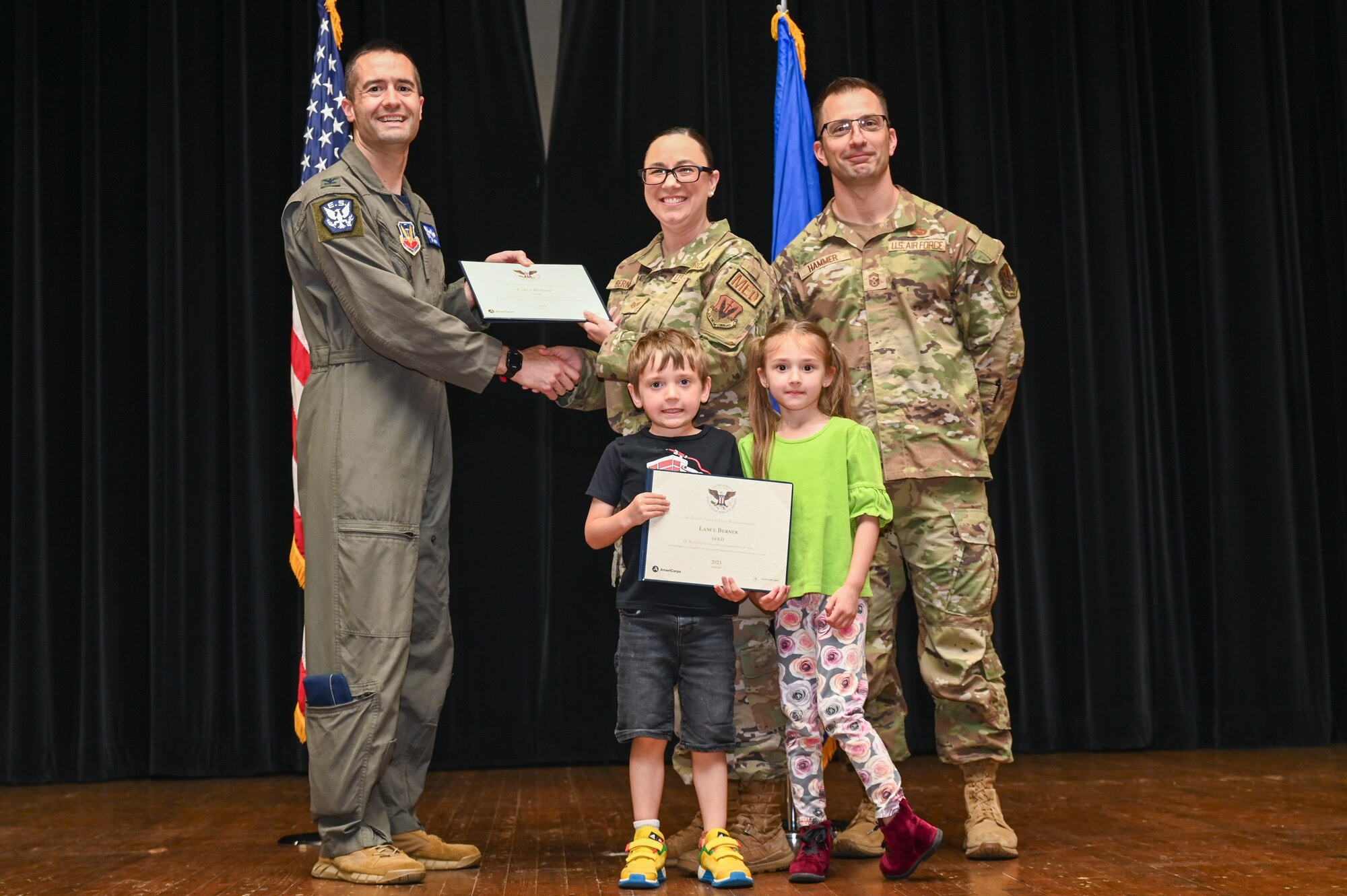 Col. Morgan Lohse, left, 4th Fighter Wing commander, and Chief Master Sgt. Paul Hammer, right, 4th Fighter Wing command chief, present the Gold Presidential Volunteer Service Award to a Seymour Johnson Air Force Base volunteer during a volunteer appreciation ceremony at Seymour Johnson Air Force Base, North Carolina, April 26, 2024. The Gold award winners have completed 250 or more hours for young adults, 500 or more hours for adults and 1,000 or more for families and groups. (U.S. Air Force photo by Airman Rebecca Tierney)