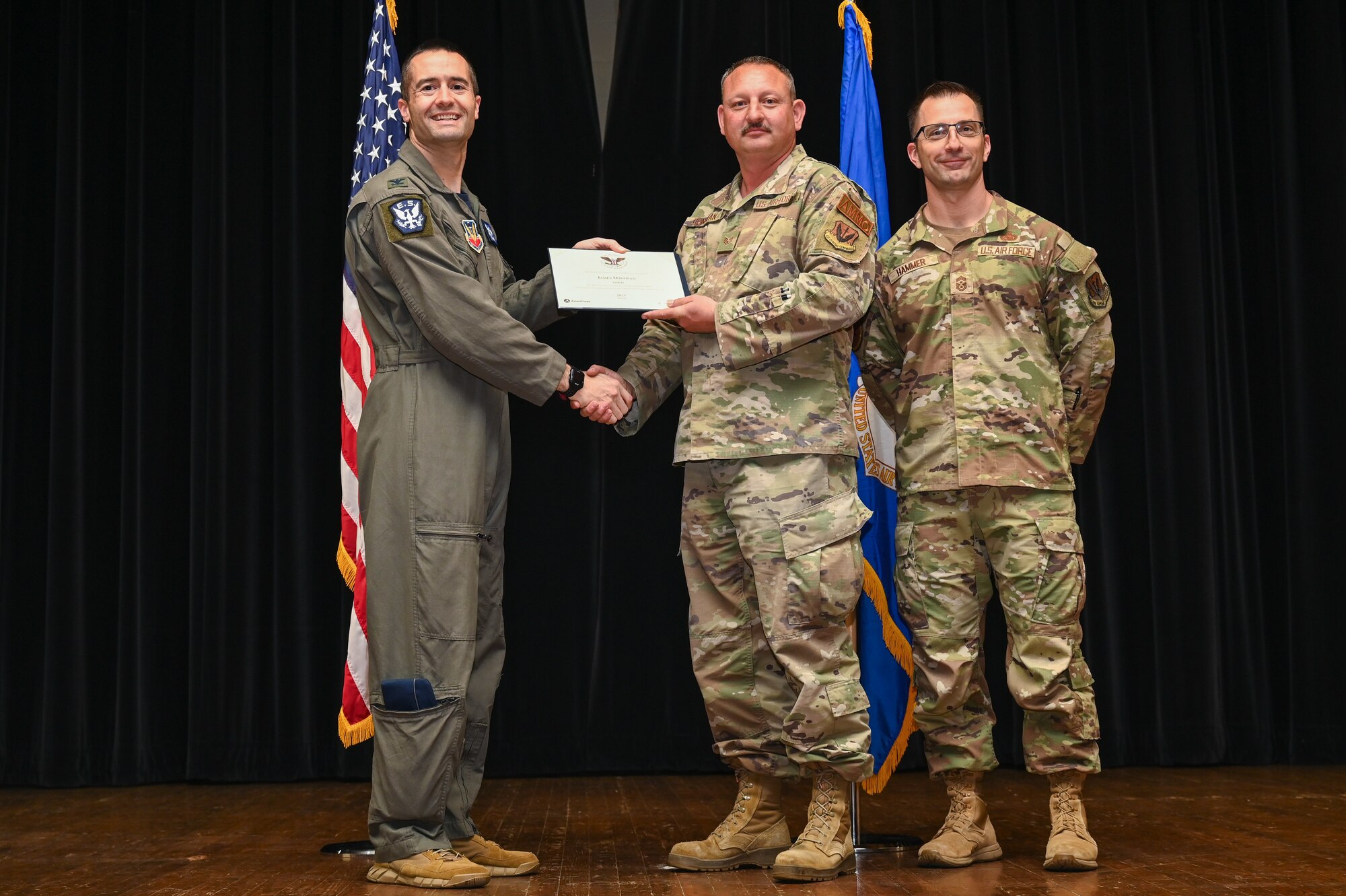 Col. Morgan Lohse, left, 4th Fighter Wing commander, and Chief Master Sgt. Paul Hammer, right, 4th Fighter Wing command chief, present the Gold Presidential Volunteer Service Award to a Seymour Johnson Air Force Base volunteer during a volunteer appreciation ceremony at Seymour Johnson Air Force Base, North Carolina, April 26, 2024. The Gold award winners have completed 250 or more hours for young adults, 500 or more hours for adults and 1,000 or more for families and groups. (U.S. Air Force photo by Airman Rebecca Tierney)