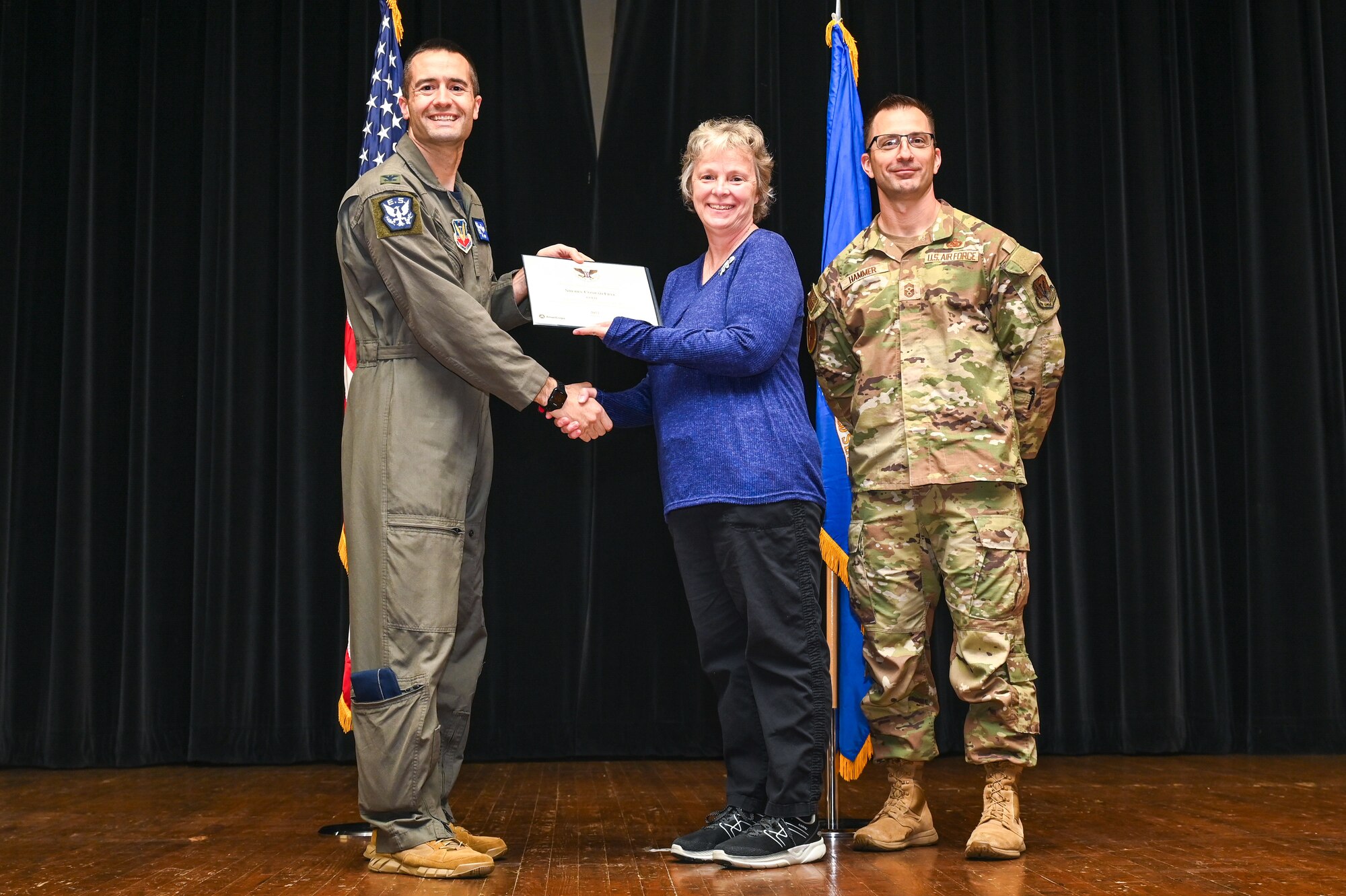 Col. Morgan Lohse, left, 4th Fighter Wing commander, and Chief Master Sgt. Paul Hammer, right, 4th Fighter Wing command chief, present the Gold Presidential Volunteer Service Award to a Seymour Johnson Air Force Base volunteer during a volunteer appreciation ceremony at Seymour Johnson Air Force Base, North Carolina, April 26, 2024. The Gold award winners have completed 250 or more hours for young adults, 500 or more hours for adults and 1,000 or more for families and groups. (U.S. Air Force photo by Airman Rebecca Tierney)