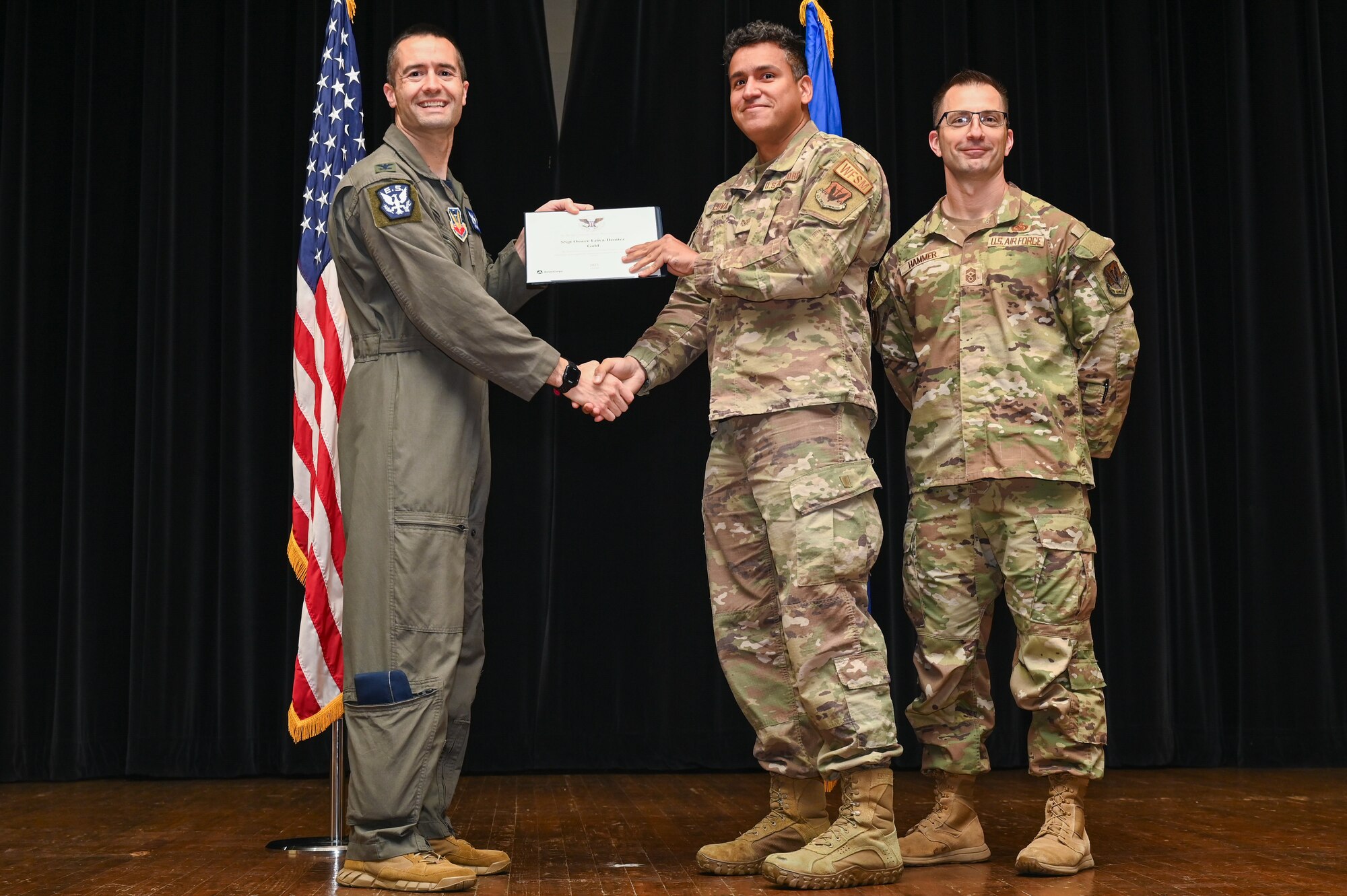 Col. Morgan Lohse, left, 4th Fighter Wing commander, and Chief Master Sgt. Paul Hammer, right, 4th Fighter Wing command chief, present the Gold Presidential Volunteer Service Award to a Seymour Johnson Air Force Base volunteer during a volunteer appreciation ceremony at Seymour Johnson Air Force Base, North Carolina, April 26, 2024. The Gold award winners have completed 250 or more hours for young adults, 500 or more hours for adults and 1,000 or more for families and groups. (U.S. Air Force photo by Airman Rebecca Tierney)