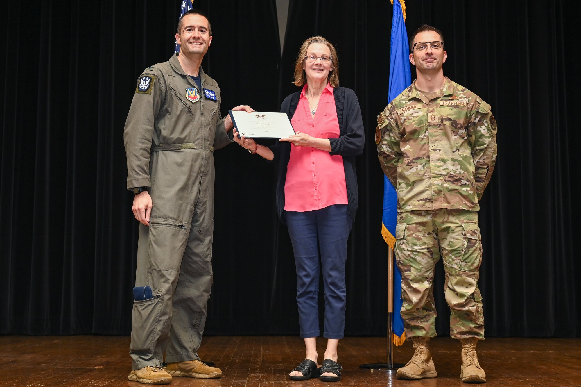 Col. Morgan Lohse, left, 4th Fighter Wing commander, and Chief Master Sgt. Paul Hammer, right, 4th Fighter Wing command chief, present the Gold Presidential Volunteer Service Award to a Seymour Johnson Air Force Base volunteer during a volunteer appreciation ceremony at Seymour Johnson Air Force Base, North Carolina, April 26, 2024. The Gold award winners have completed 250 or more hours for young adults, 500 or more hours for adults and 1,000 or more for families and groups. (U.S. Air Force photo by Airman Rebecca Tierney)