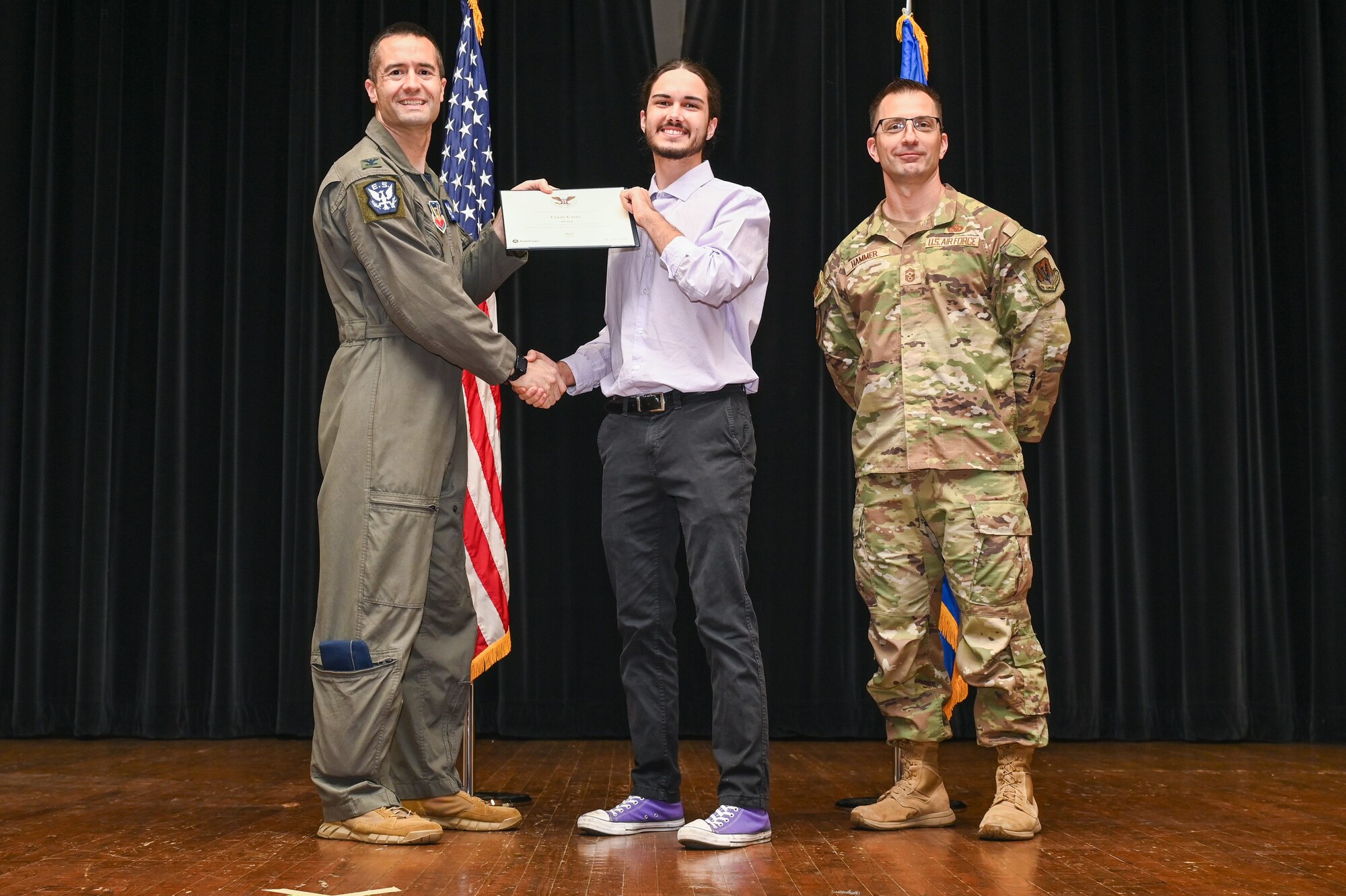 Col. Morgan Lohse, left, 4th Fighter Wing commander, and Chief Master Sgt. Paul Hammer, right, 4th Fighter Wing command chief, present the Gold Presidential Volunteer Service Award to a Seymour Johnson Air Force Base volunteer during a volunteer appreciation ceremony at Seymour Johnson Air Force Base, North Carolina, April 26, 2024. The Gold award winners have completed 250 or more hours for young adults, 500 or more hours for adults and 1,000 or more for families and groups. (U.S. Air Force photo by Airman Rebecca Tierney)