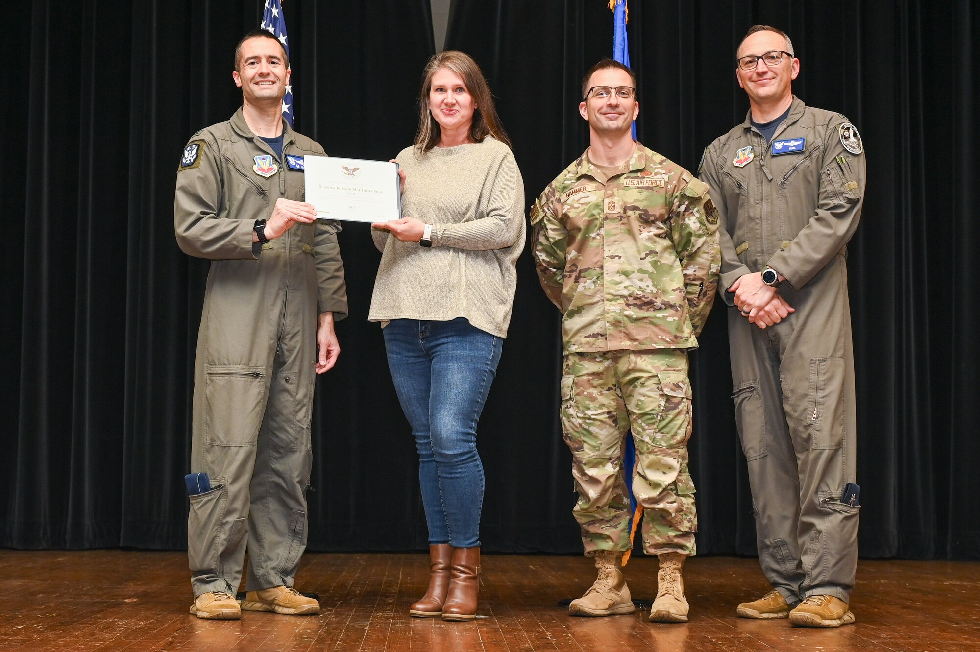 Col. Morgan Lohse, left, 4th Fighter Wing commander, and Col. Steven Bofferding, right, 4th Fighter Wing deputy commander, present the Gold Presidential Volunteer Service Award to Seymour Johnson Air Force Base volunteers during a volunteer appreciation ceremony at Seymour Johnson Air Force Base, North Carolina, April 26, 2024. The Gold award winners have completed 250 or more hours for young adults, 500 or more hours for adults and 1,000 or more for families and groups. (U.S. Air Force photo by Airman Rebecca Tierney)