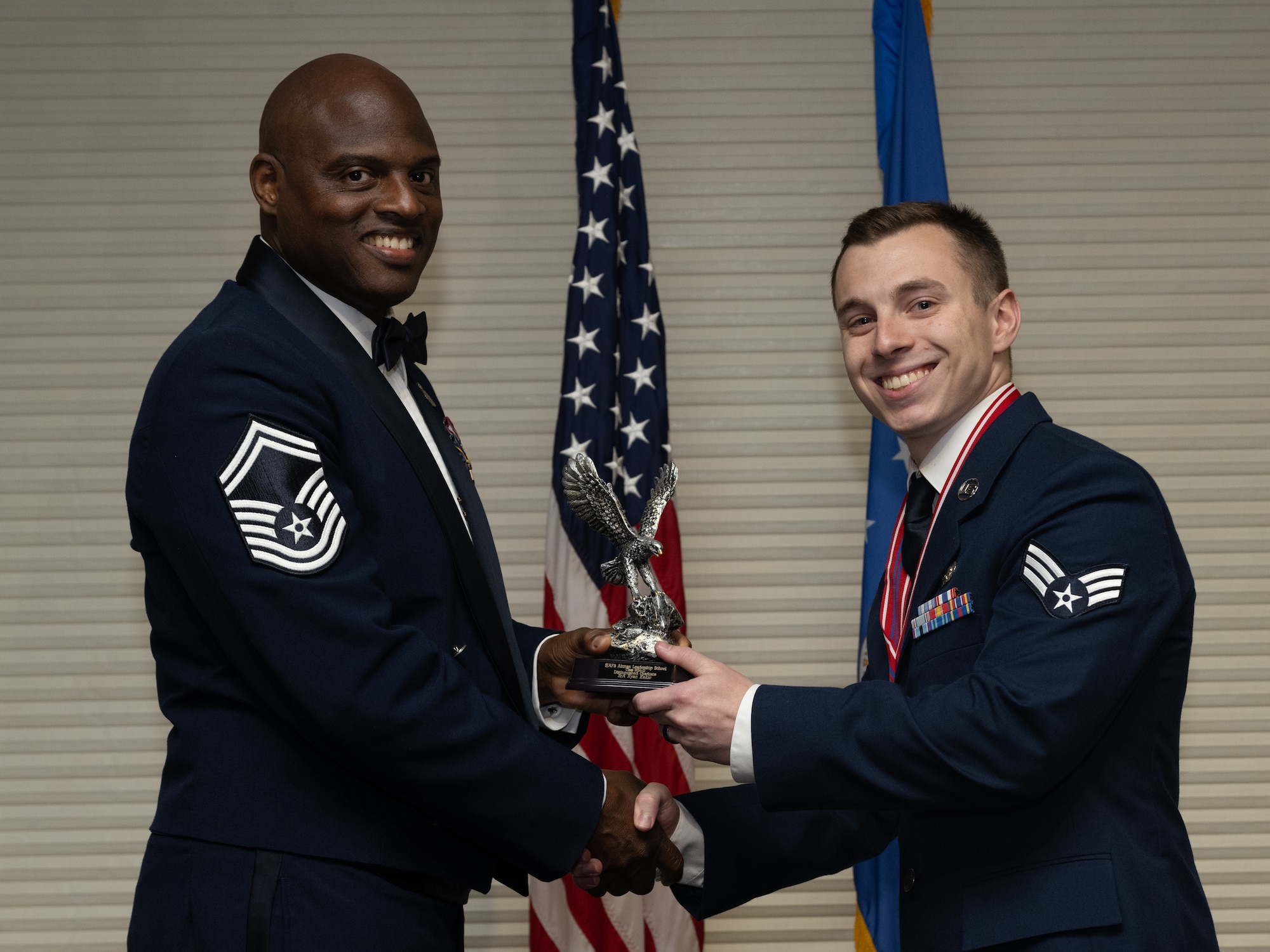 U.S. Air Force Senior Airman Ryan Kekic,4th Logistics Readiness Squadron customer service technician, receives the Distinguished Graduate Award from Senior Master Sgt. Torrey Byrd, Maintenance Operations flight weapons superintendent, during the Airman Leadership School class 24-D graduation ceremony at Seymour Johnson Air Force Base, North Carolina, May 2, 2024. Students who received the Distinguished Graduate Award displayed effective teamwork, academic excellence and leadership skills. (U.S. Air Force photo by Airman Megan Cusmano)
