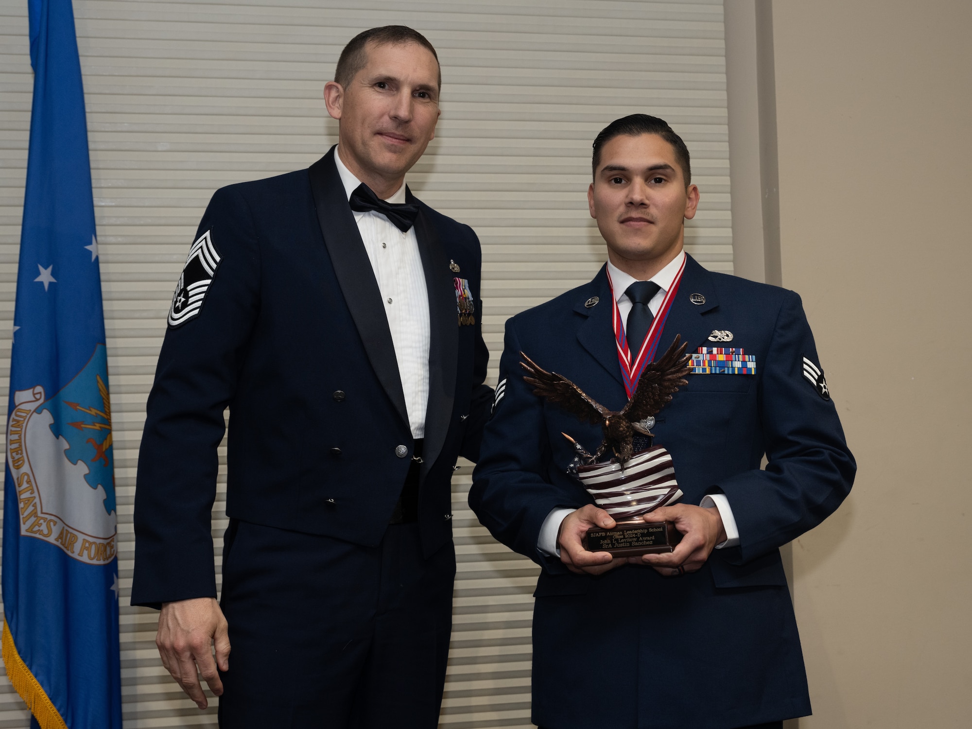 U.S. Air Force Senior Airman Justin Sanchez, 336th Fighter Generation Squadron dedicated crew chief, receives the John L. Levitow Award from Chief Master Sgt. Michael Birmingham, 916th Maintenance Squadron senior enlisted leader during the Airman Leadership School class 24-D graduation ceremony at Seymour Johnson Air Force Base, North Carolina, May 2, 2024. The John L. Levitow Award is the highest honor that can be earned by an Enlisted Professional Military Education graduate. (U.S. Air Force photo by Airman Megan Cusmano)