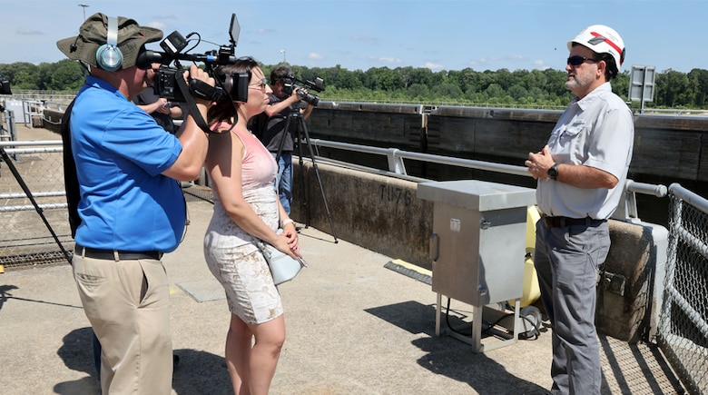News crew interviewing a Corps Employee on top of a Dam
