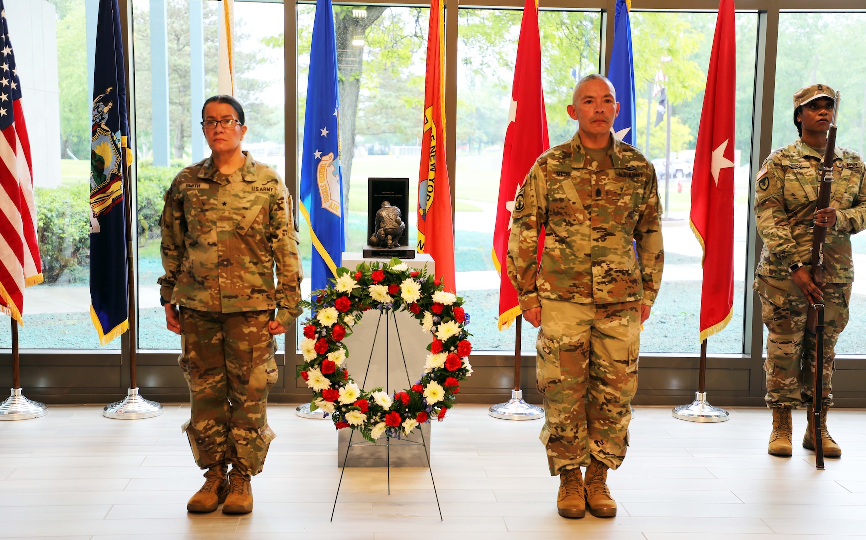 New York Army National Guard Brig Gen. Isabel Smith, the director of joint staff, and Command Sgt. Major Curtis Moss stand at attention during the playing of taps after placing a wreath at the New York National Guard headquarters Memorial Day ceremony in Latham, New York, May 23, 2024. The first Memorial Day, or Decoration Day as it was called after the Civil War, was held in New York.