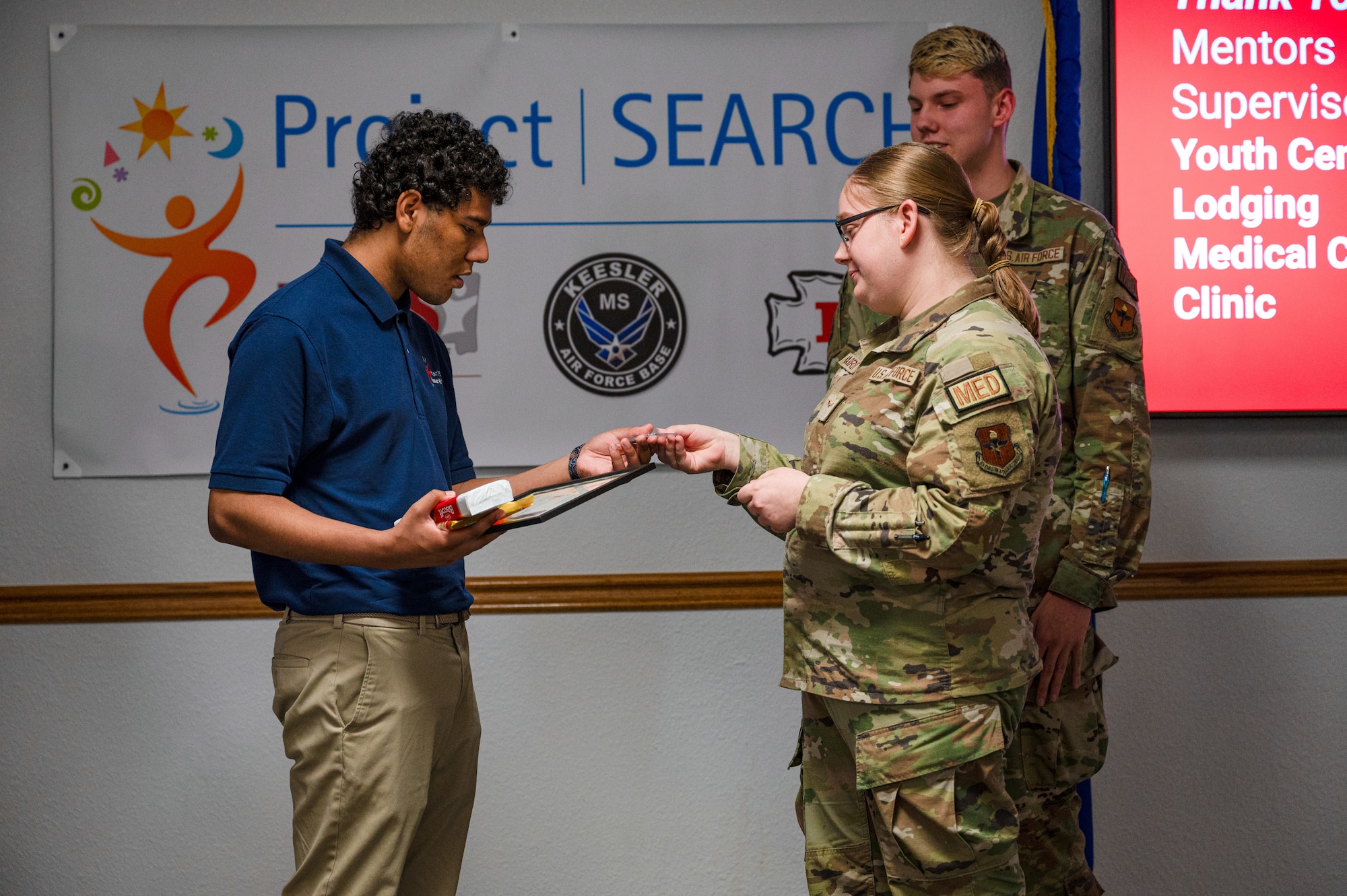DeShawn Donaldson, Project SEARCH intern receives a coin and other gifts from 81st Medical Group Airmen during the Project SEARCH graduation on Keesler Air Force Base, Mississippi, May 21, 2024.