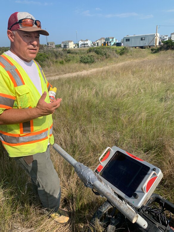 Larry Pluss, a subcontractor with Red Badger Underground, Inc., locator. A contract was awarded to remove a pipe thought to be the potential source that could have resulted in the odors, sheen, and contaminated organic material reported to the U.S. Army Corps of Engineers by the National Park Service. Pluss used a ground penetrating radar to locate and mark pipes and other anomalies found under the soil at the former Buxton Naval Facility, a Formerly Used Defense Site located in Dare County, North Carolina.