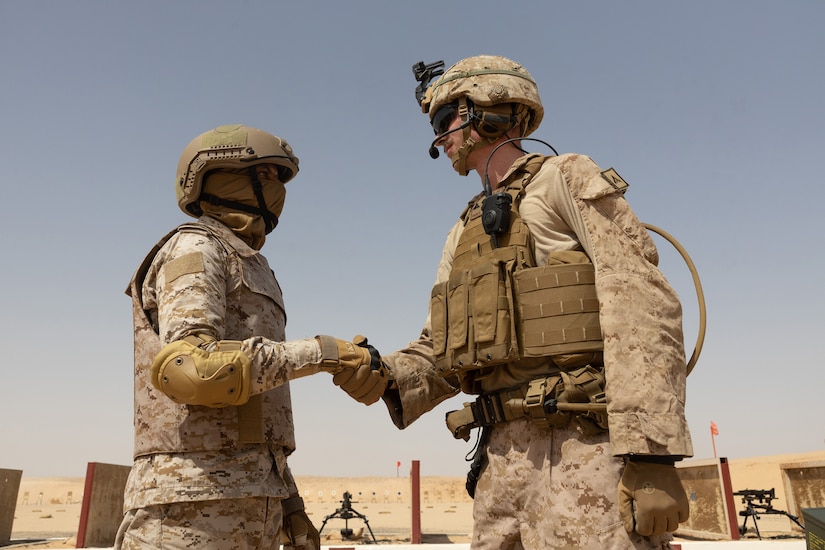 A U.S. service member shakes hands with a member of a foreign military.