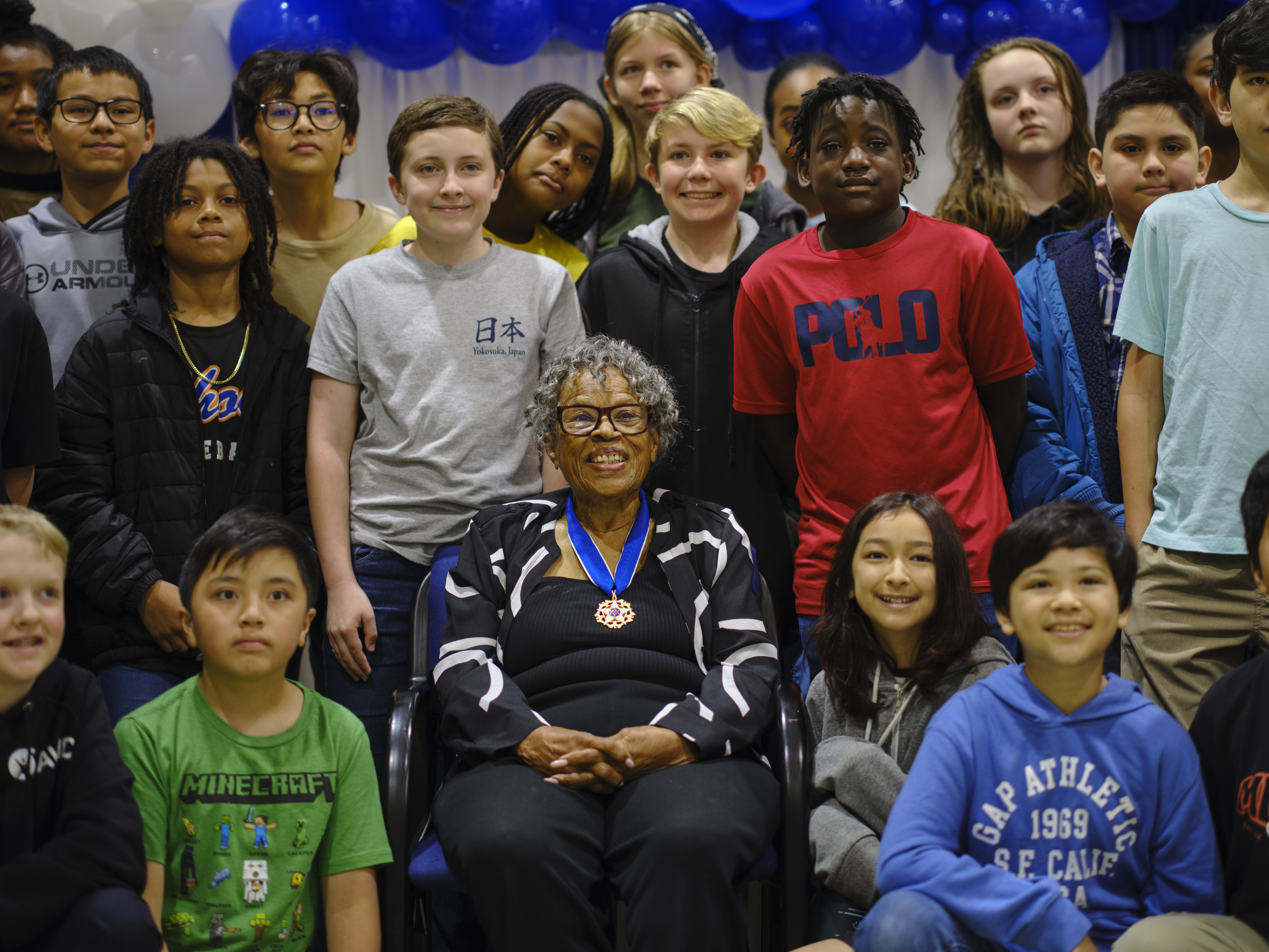 Dr. Opal Lee, the grandmother of Juneteenth and Presidential Medal of Freedom honoree, poses for a photo with students from Yokosuka Middle School May 20, 2024 at Commander, Fleet Activities Yokosuka.