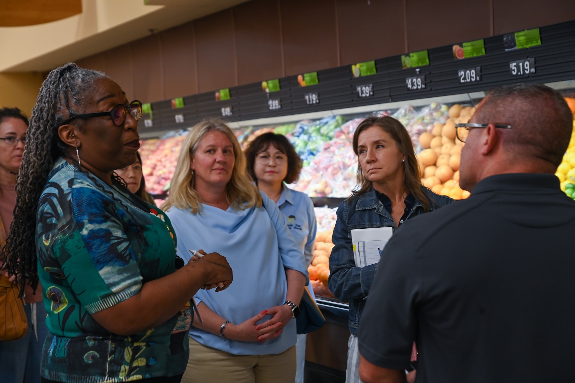 Paula Bennett, Osan Air Base Commissary store director, provides an orientation to Chris McCool, right, and Lori Schneider, second from right, Pacific Air Forces command team spouses, during a visit to the Republic of Korea, May 23, 2024.