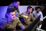 From left, U.S. Army Capt. Dahlin Draper, special technical operations deputy chief, U.S. Navy Lt. Cdr. Thomas Kasmer, future operations planner, U.S. Space Force Sgt. Daniel Diaz, space battle manager, and Jonathan Shark, deputy director of training, observe computer screens at Schriever Space Force Base, Colo., May 10-14, 2024. Members of the National Space Defense Center demonstrated the ability to transmit tasks to U.S. Navy assets as part of the threat-focused space domain awareness mission. (U.S. Space Force photo by Dennis Rogers)