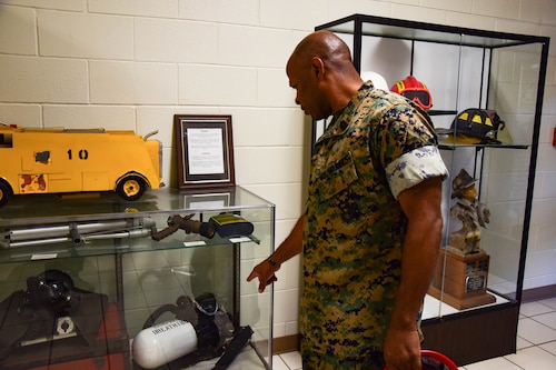 U.S. Marine Corps Master Gunnery Sgt. Terrail Dickerson, Marine Corps Detachment Goodfellow Air Force Base Fire Company senior enlisted advisor, looks at display cases with similar versions of the equipment he used at the beginning of his career, Louis F. Garland Department of Defense Fire Academy, Goodfellow AFB, Texas, May 8, 2024. Post 9/11, one of the biggest innovations to Aircraft Rescue and Firefighting was the equipment as the attacks highlighted the need to better equip firefighters for protection and efficiency. (U.S. Marine Corps photo by Cpl. Jessica Roeder)