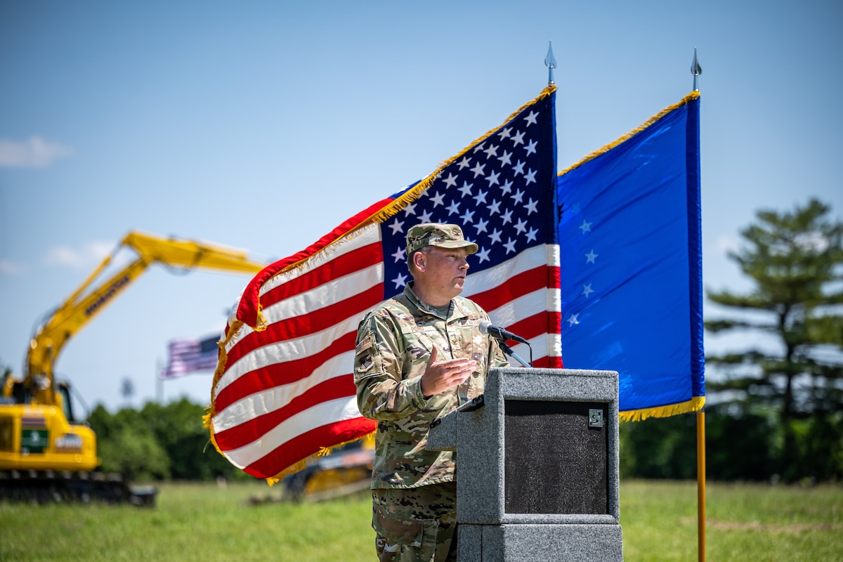 Col. Pond gives a speech behind a podium in front of the U.S. and Air Force flags