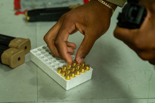 A hand reaches for ammunition.
