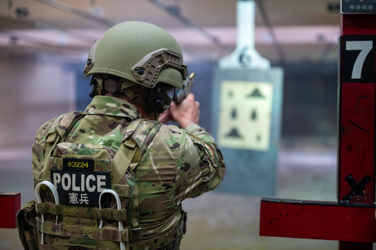 Airman aims weapon at target.