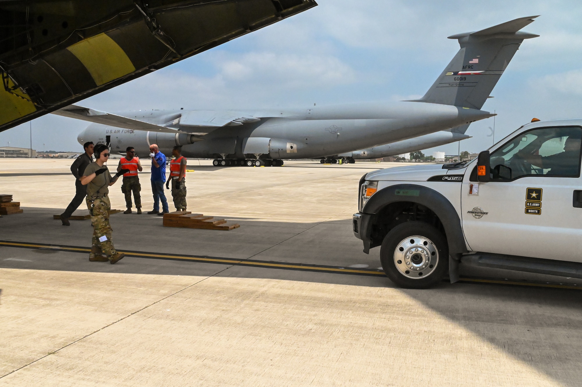 SSgt. Jennifer Oveson, a 68th Airlift Squadron loadmaster, ground guides a vehicle from U.S. Army North’s Task Force 51 in preparation for loading on to a 433rd Airlift Wing C-5M Super Galaxy as part of joint cargo upload training at Joint Base San Antonio-Lackland, Texas May 20, 2024.