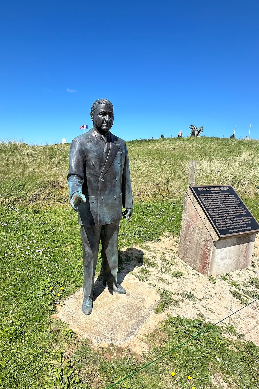 A statue of a person in position on a beach.