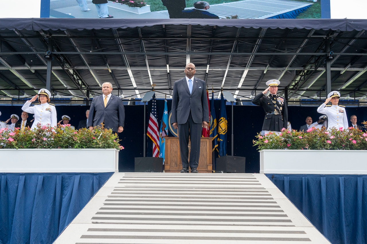 Four people stand on a stage.