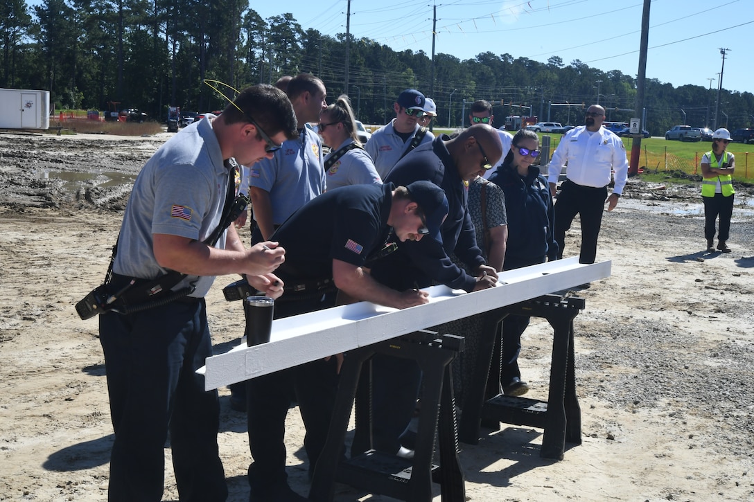 Members of Marine Corps Base Camp Lejeune's Fire and Emergency Services take turns signing the beam for Military Construction Project 1518, the new Hadnot Point Fire Station at Marine Corps Base Camp Lejeune.  



“Topping out” ceremonies are informal ceremonies used to commemorate a construction milestone for the completion of the foundational structure of a building. During the ceremony, project key players sign the beam prior to its placement on top of the structure.