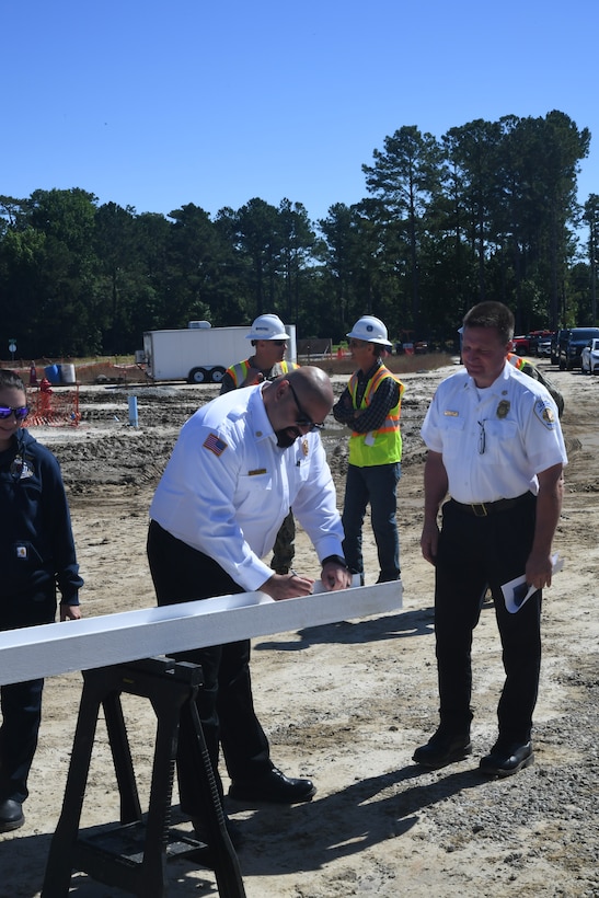 Alex Rivera, Region/Installation fire chief for MCI East - MCB Camp Lejeune and Marine Corps Air Station New River signs the metal beam during the “topping out” ceremony for Military Construction Project 1518, the new Hadnot Point Fire Station aboard Marine Corps Base Camp Lejeune on May 21, 2024. 



“Topping out” ceremonies are informal ceremonies used to commemorate a construction milestone for the completion of the foundational structure of a building. During the ceremony, project key players sign the beam prior to its placement on the structure.
