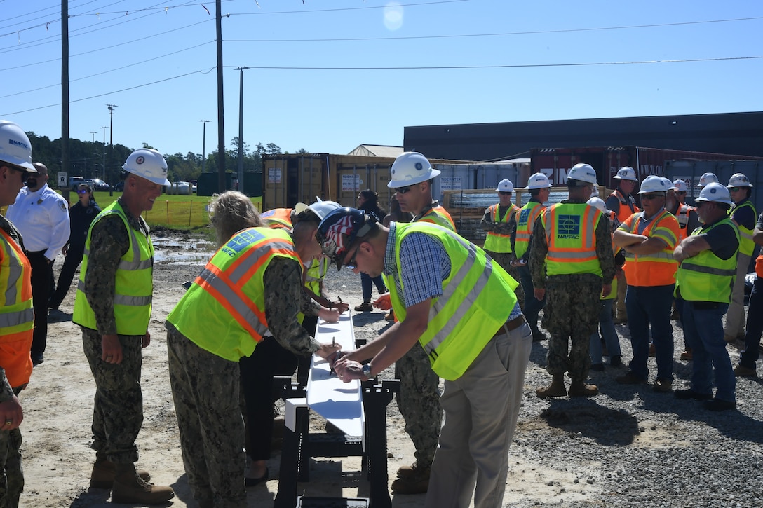 Members of OICC Florence and guests from Marine Corps Base Camp Lejeune take turns signing the beam for Military Construction Project 1518, the new Hadnot Point Fire Station at Marine Corps Base Camp Lejeune.  



“Topping out” ceremonies are informal ceremonies used to commemorate a construction milestone for the completion of the foundational structure of a building. During the ceremony, project key players sign the beam prior to its placement on top of the structure.