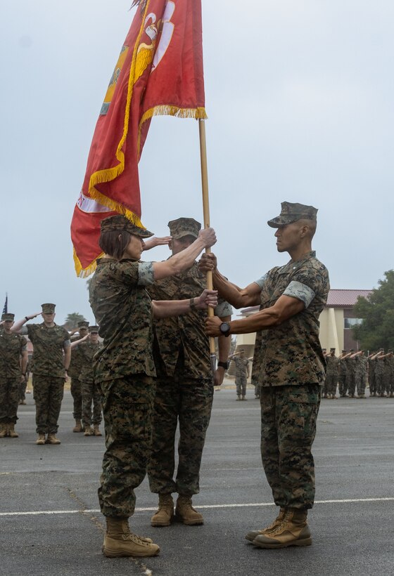 U.S. Marine Corps Lt. Col. Alisson W. Hickman, left, oncoming commanding officer of I Marine Expeditionary Force Support Battalion, I MEF Information Group, receives the organizational colors from Lt. Col. John Shim, outgoing commanding officer of I MSB, during a change of command ceremony at Marine Corps Base Camp Pendleton, California, May 24, 2024. The ceremony commemorates the passing of command from Shim to Hickman. (U.S. Marine Corps photo by Cpl. Gabriela Garcia-Gregorio)
