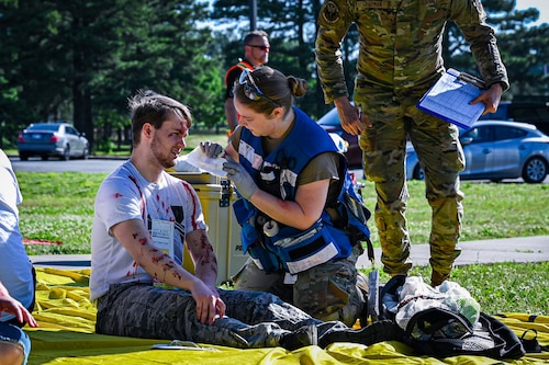 A medical member provides care to a casualty role player to simulate a medical exercise.
